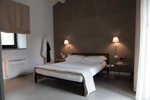 sypialnia z łóżkiem, dwoma stołami i dwoma lampami w obiekcie Talè Restaurant & Suite w mieście Piedimonte Etneo