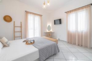 um quarto branco com uma cama e 2 janelas em Disis Residence em Naxos Chora