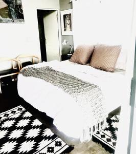a bedroom with a bed with a black and white rug at 3 Indigo in Hermanus