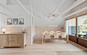a dining room with a table and white chairs at 2 Bedroom Beautiful Home In Thyholm in Thyholm