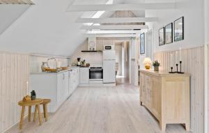 a large white kitchen with white appliances and wooden floors at 2 Bedroom Beautiful Home In Thyholm in Thyholm