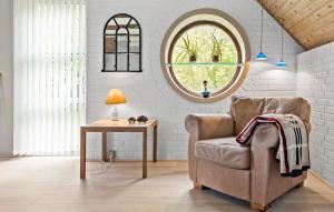 a living room with a chair and a table at 2 Bedroom Beautiful Home In Thyholm in Thyholm
