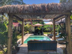a pool with a pergola and a bench next to a swimming pool at Meno Dream Resort in Gili Meno
