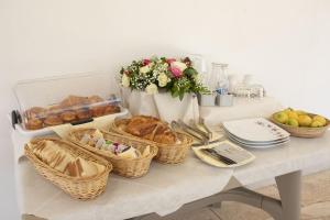 una tavola con cesti di pane e altri alimenti su di essa di Villa Dalesco a Leverano