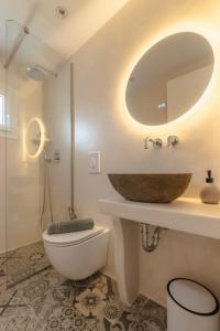 W łazience znajduje się umywalka, toaleta i lustro. w obiekcie Disis Residence w mieście Naksos