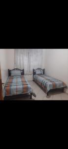 2 Betten nebeneinander in einem Zimmer in der Unterkunft Avito maroc in Oulad Yakoub