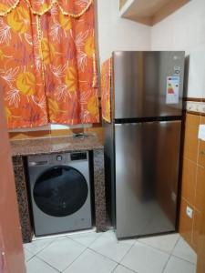 einen Kühlschrank aus Edelstahl und eine Mikrowelle in der Küche in der Unterkunft Avito maroc in Oulad Yakoub