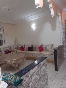 ein Wohnzimmer mit einem Sofa und roten Kissen in der Unterkunft Avito maroc in Oulad Yakoub