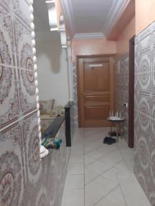 ein Badezimmer mit einer Holztür und Fliesenboden in der Unterkunft Avito maroc in Oulad Yakoub