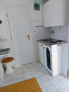 cocina blanca con fogones y fregadero en Apartment Ma're, en Supetar