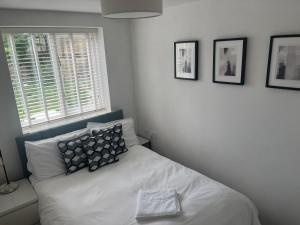 1 dormitorio con cama con almohada y ventana en 116 The Pond House, en Holmfirth
