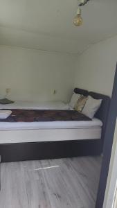 una cama con almohadas en una habitación en Minivilla in Gustavsvik Nacka, en Gustavsvik