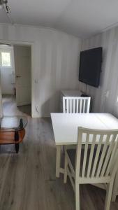 sala de estar con mesa blanca y TV en Minivilla in Gustavsvik Nacka, en Gustavsvik