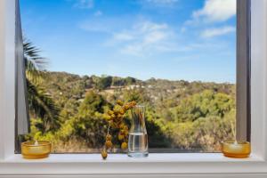 a vase sitting on a window sill with a view at Hill Moi Country stay by the Sea in Victor Harbor