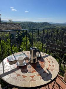 un tavolo con bollitore per tè e caffè su un balcone di Casa Bella Vista a Pereta