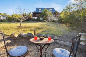 a table with two chairs and two glasses of wine at Hill Moi Country stay by the Sea in Victor Harbor