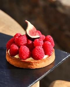 a cake with raspberries on top of it on a table at Hôtel La Mandarine in Saint-Tropez