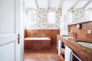 La salle de bains est pourvue de 2 lavabos et d'une baignoire. dans l'établissement Relais & Chateaux Hotel Castel Fragsburg, à Merano