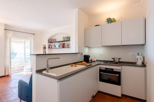 Una cocina con gabinetes blancos y un fregadero. en Wonderful Villa In Mulinetti, en Recco
