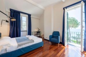 1 dormitorio con cama, silla azul y ventana en Wonderful Villa In Mulinetti, en Recco