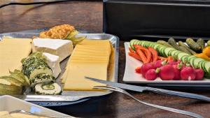 twee dienbladen kaas en groenten op een tafel bij Altstadthotel Goldene Kugel in Waren