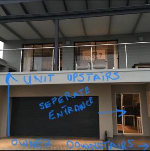 un cartel en la parte delantera de un edificio con graffiti azul en 3 Indigo en Hermanus