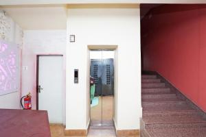 un pasillo con escaleras y una pared roja en Flagship Imperial Guest House, en Bārāsat