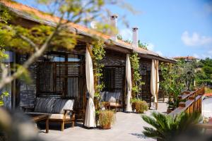 a patio with chairs and a building with vines at MAVİ AT HOTEL Blue Horse in Gümüşdere