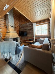 un soggiorno con divano e camino di Rauhallinen kelohuoneisto lähellä palveluita, Peacefull Log apartment at Ylläs a Ylläsjärvi