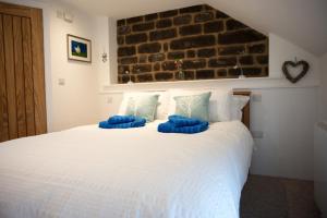 a bedroom with a large white bed with blue pillows at Anroach Farm Peak District in Buxton