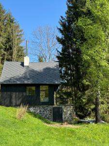 una pequeña casa en una colina con un árbol en Tré, en Čenkovice