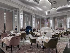 a restaurant with tables and chairs in a room at The Langham London in London