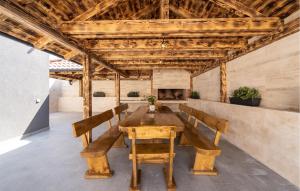 a dining room with a wooden table and benches at Gorgeous Home In Miranje Donje in Vrana