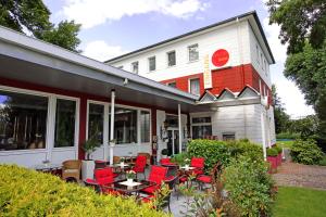 a restaurant with red chairs and tables in front of it at Arena Hotel in Gelsenkirchen