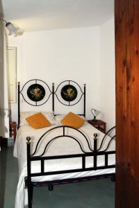 1 dormitorio con 1 cama negra y 2 almohadas de color naranja en Tenuta Petreria en Santo Stefano di Camastra