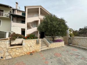 a large building with a tree in front of it at APARTMAN 2 Istočna Gomilica in Tisno +22 photos