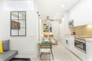 Il dispose d'une cuisine et d'un salon avec un canapé et une table. dans l'établissement Apartamento Bernabeu Comfort en Madrid, à Madrid