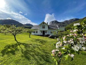 a white house on a green field with flowers at Hauane Bed and Breakfast in Sandnes