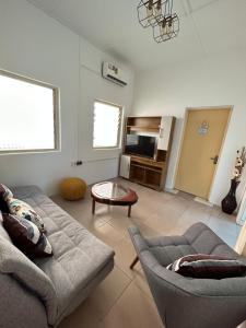 uma sala de estar com um sofá e uma mesa em Big & confortable house in Oxford street Barnor em Acra