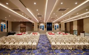 a conference room with white chairs and a stage at Sayaji Pune in Pune