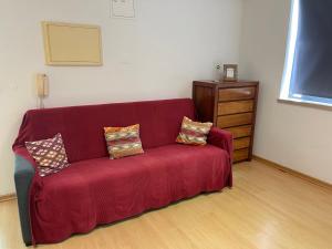 - un canapé rouge avec deux oreillers dans le salon dans l'établissement Industrial Loft, à Sintra