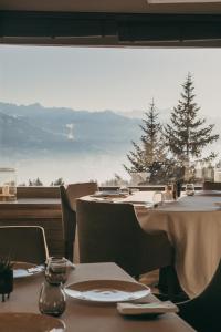 two tables in a restaurant with a view of the mountains at LeCrans in Crans-Montana