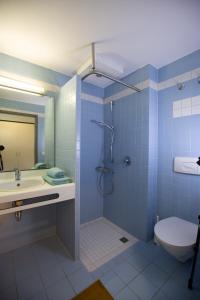 a bathroom with a shower and a sink and a toilet at MAGNET Boardinghouse in Schkeuditz