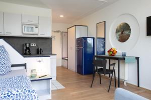 a room with a bed and a kitchen with a table at MAGNET Boardinghouse in Schkeuditz