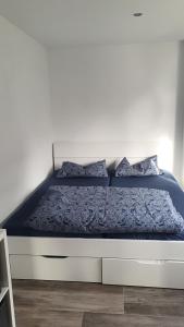 a white bed with blue sheets and pillows on it at FeWo Drei Gleichen- Nr2 in Wandersleben