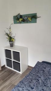 a bedroom with a white cabinet with a potted plant on it at FeWo Drei Gleichen- Nr2 in Wandersleben