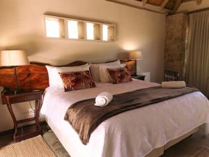 a bedroom with a large white bed with a wooden headboard at Oluchi Lodge in Guthrie