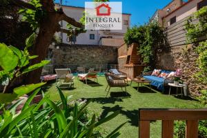 a garden with chairs and a couch on grass at Casa MareMar in Palamós