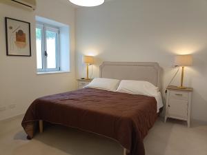 una camera da letto con un letto con due comodini e una finestra di I Limoni ad Alghero