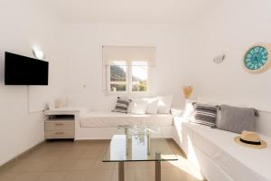 a white living room with a couch and a table at Elio A 1BDR Apt with Garden 1 min from the beach by Hospi in Heraklio Town